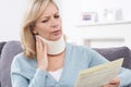 Mature Woman Reading Letter After Receiving Neck Injury