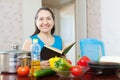 Mature woman reads cookbook for recipe Royalty Free Stock Photo