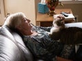 Mature women relaxes as she pets her cat Royalty Free Stock Photo
