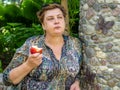 Mature woman  in the Park and eating a red Apple Royalty Free Stock Photo