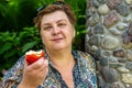 Mature woman in the Park and eating a red Apple Royalty Free Stock Photo