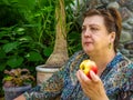 Mature woman resting  and eating a red Apple Royalty Free Stock Photo