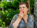 Mature woman resting and eating a red Apple Royalty Free Stock Photo