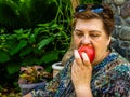 Mature woman resting in the Park and eating a red Apple Royalty Free Stock Photo