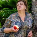 Mature woman resting in the Park and eating a red Apple Royalty Free Stock Photo