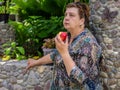 Mature woman resting in the Park and eating a red Apple Royalty Free Stock Photo