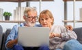 Mature woman and senior man using laptop in living room, Portrait of Worried senior couple checking their bills and work on Royalty Free Stock Photo