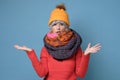 Mature woman in several hats and scarfs frowning being displeased and offended.