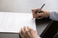 Mature woman signing document, using pen, writing in legal paper Royalty Free Stock Photo