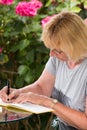 Mature woman signing a guest book Royalty Free Stock Photo