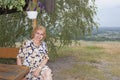 A mature woman sits at a street table on the background of a pan Royalty Free Stock Photo