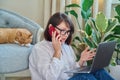 Mature woman sitting at home, using smartphone laptop Royalty Free Stock Photo