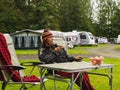 The mature woman is sitting with a vegetable smoothi in a tent camp. Life in nature, Scotland