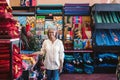 Mature woman smiling while working in her textiles shop Royalty Free Stock Photo