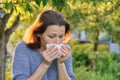 Mature woman sneezing in handkerchief, allergy to pollen, colds