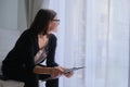 Mature woman social worker, psychologist sitting near the window with clipboard Royalty Free Stock Photo