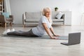 Mature woman stretching back on mat, cobra pose