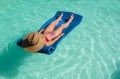 Middle-aged woman lounging lying on a mattress in the water Royalty Free Stock Photo