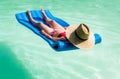 Middle-aged woman lounging lying on a mattress in the water Royalty Free Stock Photo