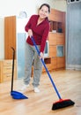 Mature woman sweeping the floor Royalty Free Stock Photo