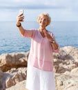 Mature woman taking selfie on beach Royalty Free Stock Photo