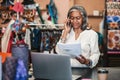 Mature woman talking on the phone in her fabric shop Royalty Free Stock Photo