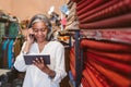 Mature woman talking on the phone in her fabric store Royalty Free Stock Photo