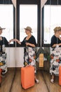 mature woman traveller, looking at herself in the mirror as she dresses to go for a walk along the coast on her summer Royalty Free Stock Photo