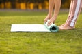 Mature woman unrolling yoga mat outdoors Royalty Free Stock Photo