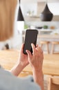 Mature Woman Using App On Mobile Phone To Control Central Heating Temperature In House Royalty Free Stock Photo