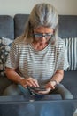 mature woman using cell phone and laptop at home Royalty Free Stock Photo