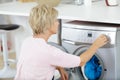 mature woman using washing machine Royalty Free Stock Photo