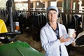 Mature woman veterinarian with milk at cowshed Royalty Free Stock Photo