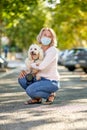 Mature woman walking with a dog outdoors an antivirus mask Royalty Free Stock Photo