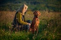 Mature woman walking her beautiful hungarian vizsla. Dog walking background. Woman and hunting dog enjoying walk.