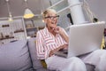 Mature woman waving to someone while having a video call over laptop at home Royalty Free Stock Photo