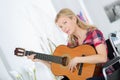 mature woman in wheelchair playing guitar Royalty Free Stock Photo