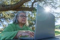 mature woman with white hair and glasses working on her computer Royalty Free Stock Photo