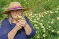 mature woman with white hair and hat holding a bouquet of daisies in her hands Royalty Free Stock Photo