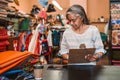 Mature woman working at a counter in her fabric shop Royalty Free Stock Photo
