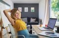 Mature woman working indoors in home office in container house in backyard, resting. Royalty Free Stock Photo