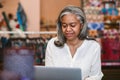 Mature woman working on a laptop in her fabric shop Royalty Free Stock Photo