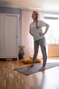 Mature woman working out indoors standing in Tadasana, Mountain Pose. Royalty Free Stock Photo