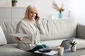 Mature woman working and talking on cellphone at home Royalty Free Stock Photo