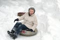 Mature woman young at heart. Happy smiling elderly female riding on snow tubing. Senior lady sledding slide down hill. Winter fun Royalty Free Stock Photo