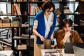 Mature woman and young man using laptop while working together in office Royalty Free Stock Photo