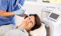 Mature woman receiving facial procedure with hydrogen and oxygen ions attachment