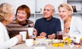 Mature women and their friend are drinking tea and talking