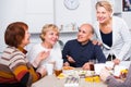 Mature women and their friend are drinking tea and talking