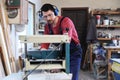 Mature working man using thickness planer